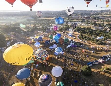 An aerial image of a mass hot air balloon ascent